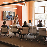 Office workers collaborating in a conference room with participants via video conference