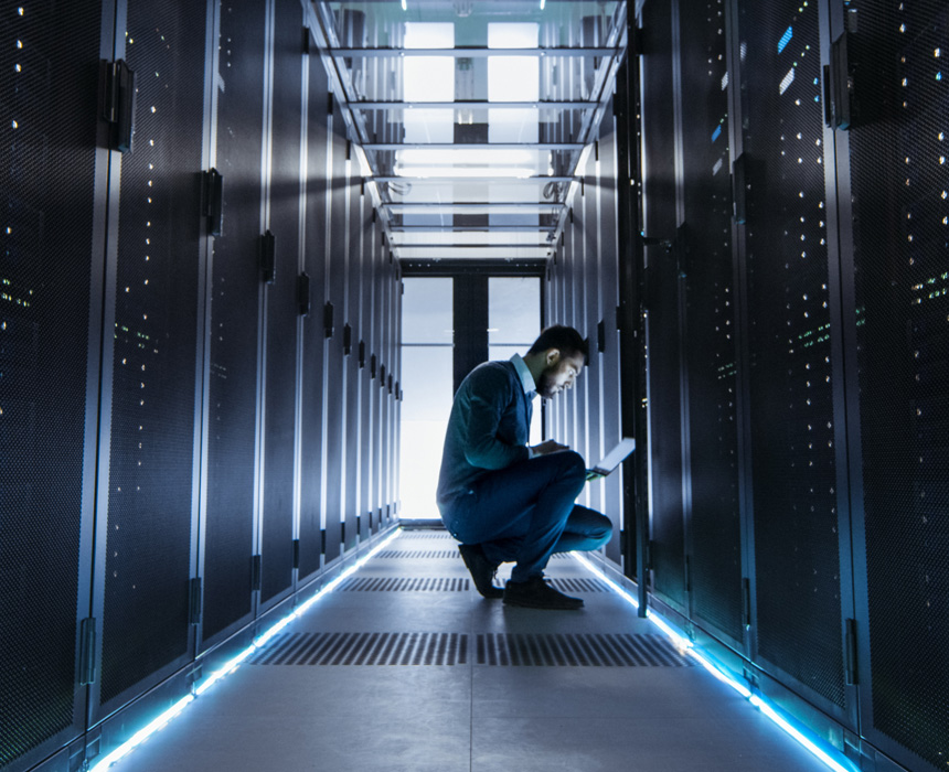 Man kneeling down analyzing information in a Data Center