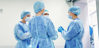 Doctors in scrubs and masks preparing for surgery