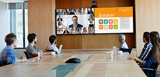 workers at a conference table participate in a video conference call