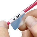 Hands applying adhesive labels to a telecommunications cable