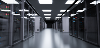 A hallway of a data center, with light panels on the ceiling and the data servers on both sides. 