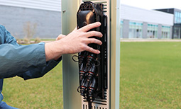 an installer places a multiport service terminal in an above-ground pedestal for outside plant fiber splicing