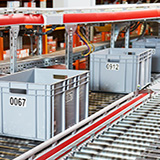 bins move on a conveyor belt to collect products in a fulfillment center