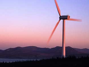 Wind Turbine at sunset with mountains in the background