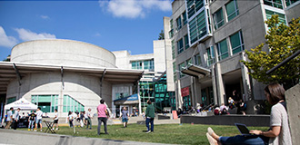 Exterior view of campus buildings and students outside on a college campus