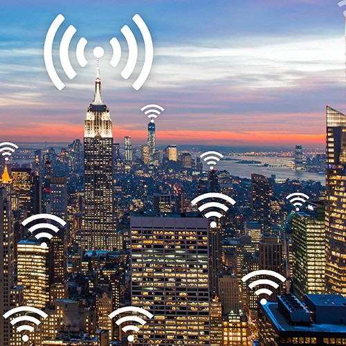 City view of high-rise buildings with icons representing wireless signals